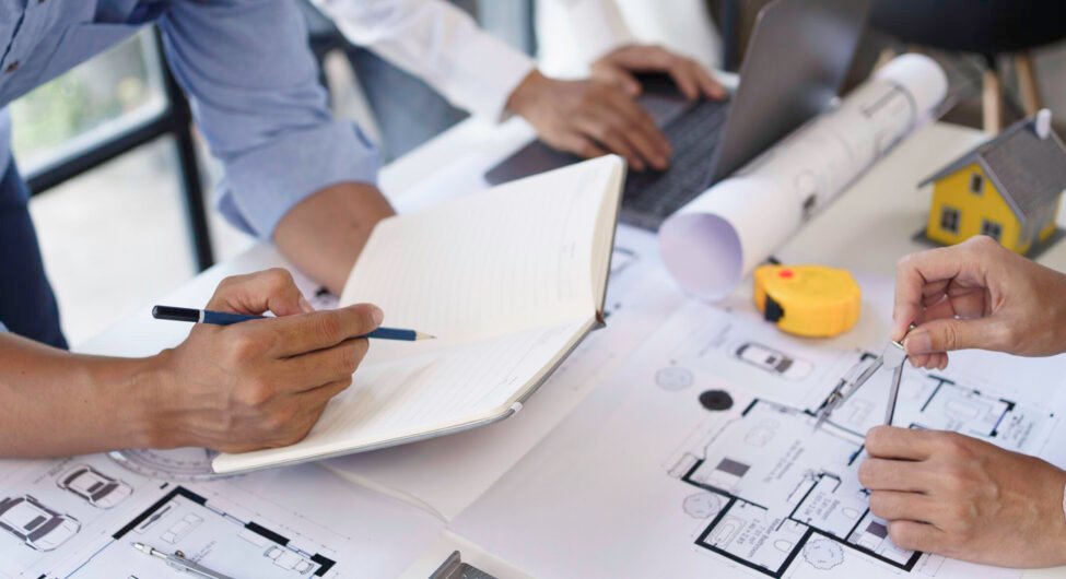 Project planning meetings with engineer or architect working together to model home and use engineering tools to create model and blueprint at work.