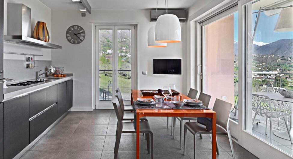 modern kitchen interior in the foreground the orange dining table with its chairs