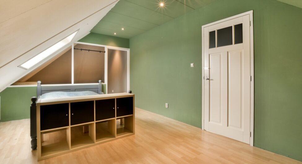 an attic bedroom with a bed and a wooden desk