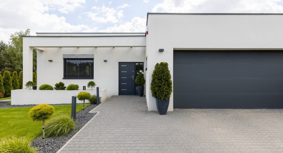 Outside view of elegant suburban house with big window green lawn