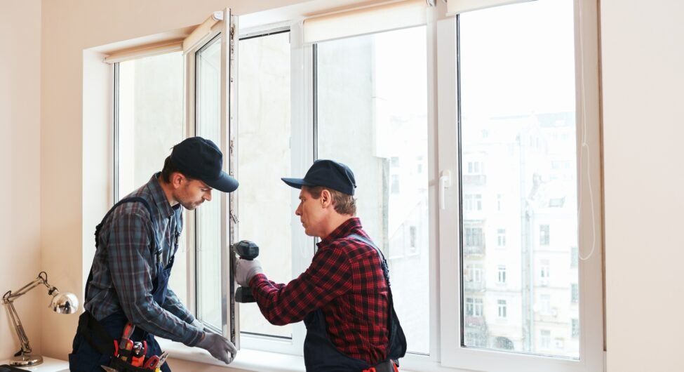 Quality light. Construction workers installing new window in house