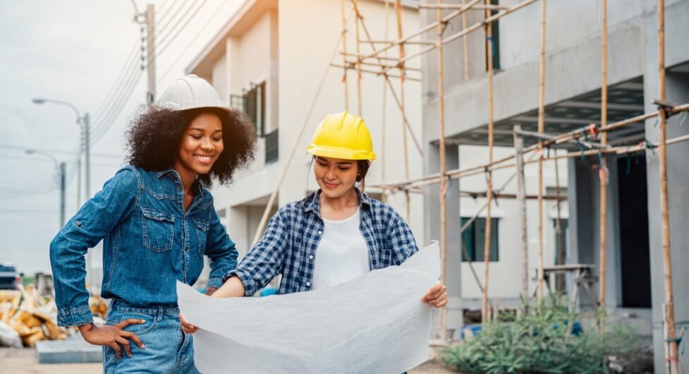 Young female architector and engineers working on building site.